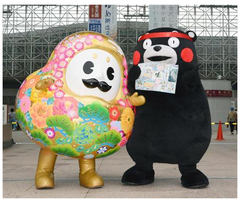 くまモンが新聞PR お手製スクラップ帳をひゃくまんさんに手渡し